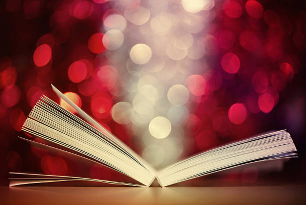 istock Open book against  defocused  lights abstract background 523427695