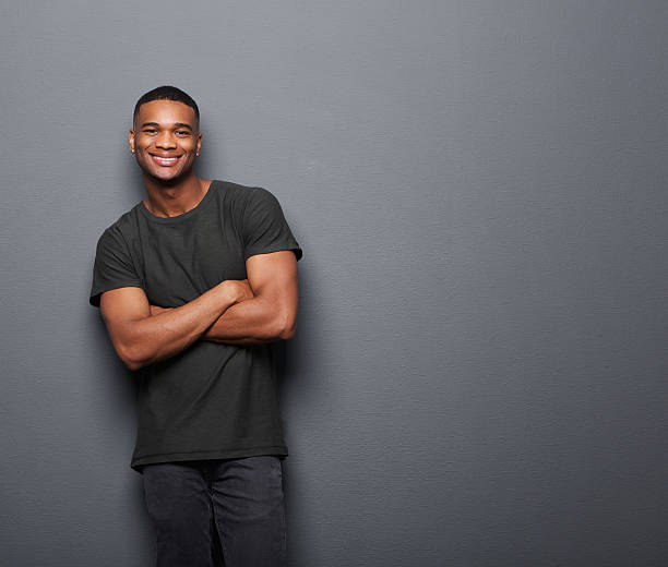 istock Happy young man standing with arms crossed 523431083