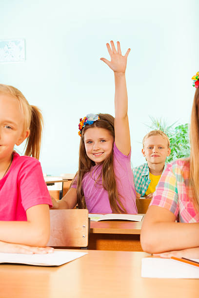 istock Smiling girl holds arm up behind her classmates 523431677
