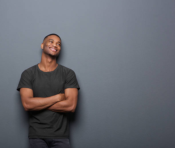 istock Cheerful young man smiling with arms crossed on gray background 523432169