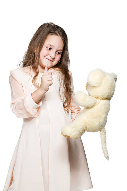 istock Girl playing with a toy teddy bear 523442045
