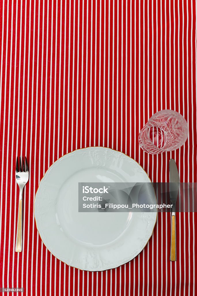 tableware on a triped red textile Formal Table Setting Closeup with reserved space for additional information Anticipation Stock Photo