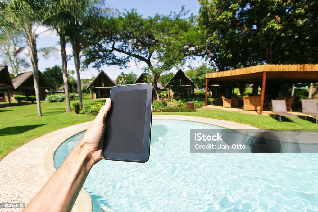 Holding tablet PC im tropischen Paradies - Lizenzfrei Auslage Stock-Foto