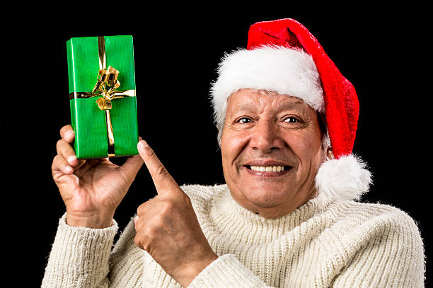 istock Gleeful Aged Man Pointing At Raised Green Present 523444459