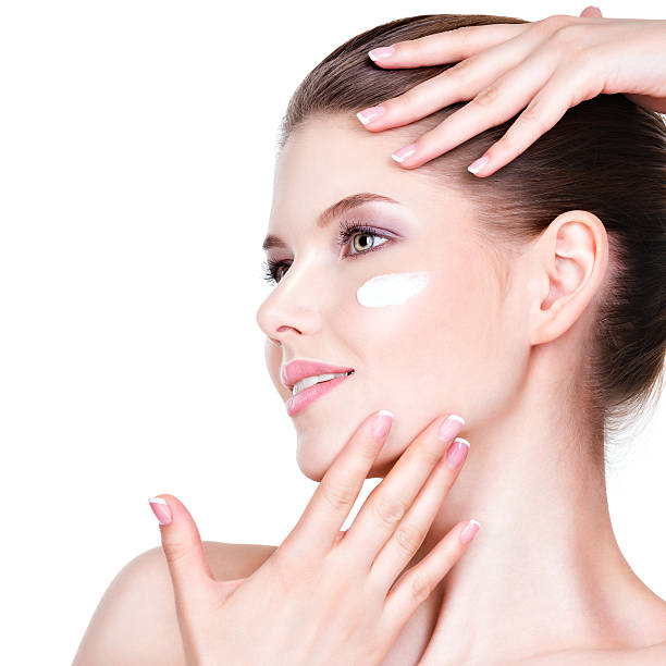 istock Young woman with cosmetic cream on a face. 523444637