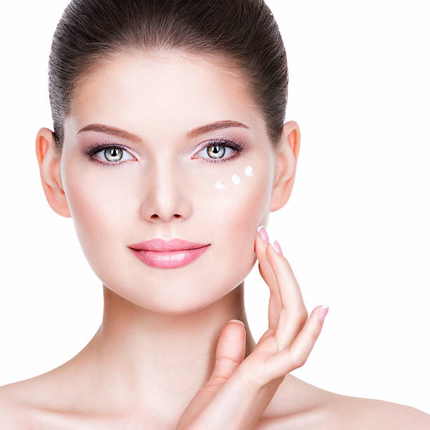 istock Young woman applying cream on her pretty face. 523445635