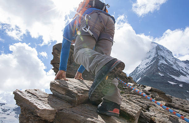 istock Climber ascends ridge leading to Matterhorn, sun streaming 523447011