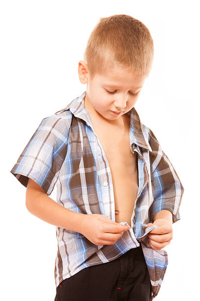 istock little boy buttoning on shirt, isolated on white 523469702