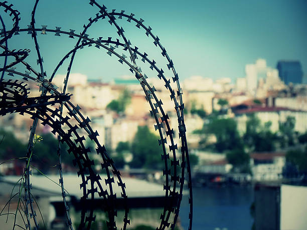 istock Barbed wire and city landscape 523470442