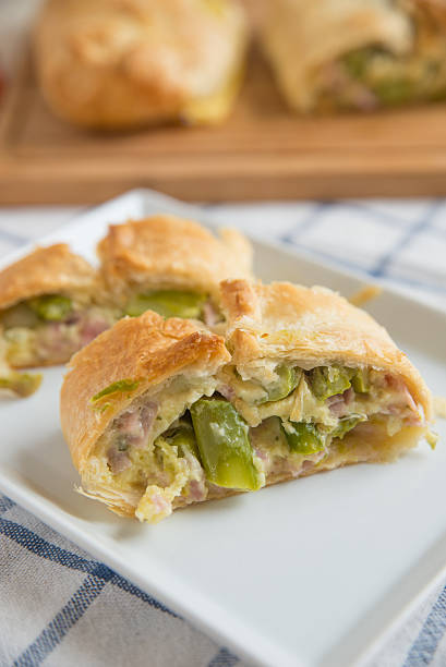 istock Pastry filled with ham, cheese and green asparagus 523470764