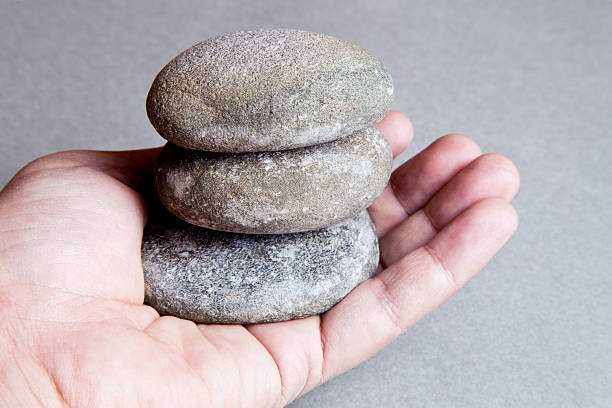 istock Close-up of person's hand holding stack of smooth pebbles 523470813