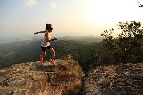 istock young asian woman runner running on mountain peak 523471528