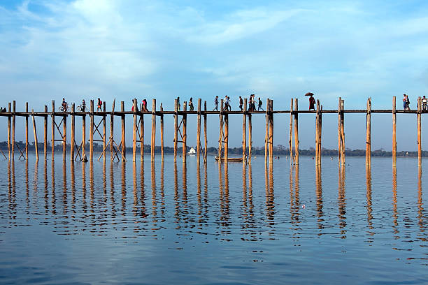 U Bein Bridge - Amarapura - Myanmar U Bein Bridge at Amarapura near Mandalay in Myanmar (Burma). The footbridge, over Taungthaman Lake, was constructed in 1849 using reclaimed teak columns by the then mayor of Amarapura, U Bein. It is 1.2Km long. u bein bridge stock pictures, royalty-free photos & images