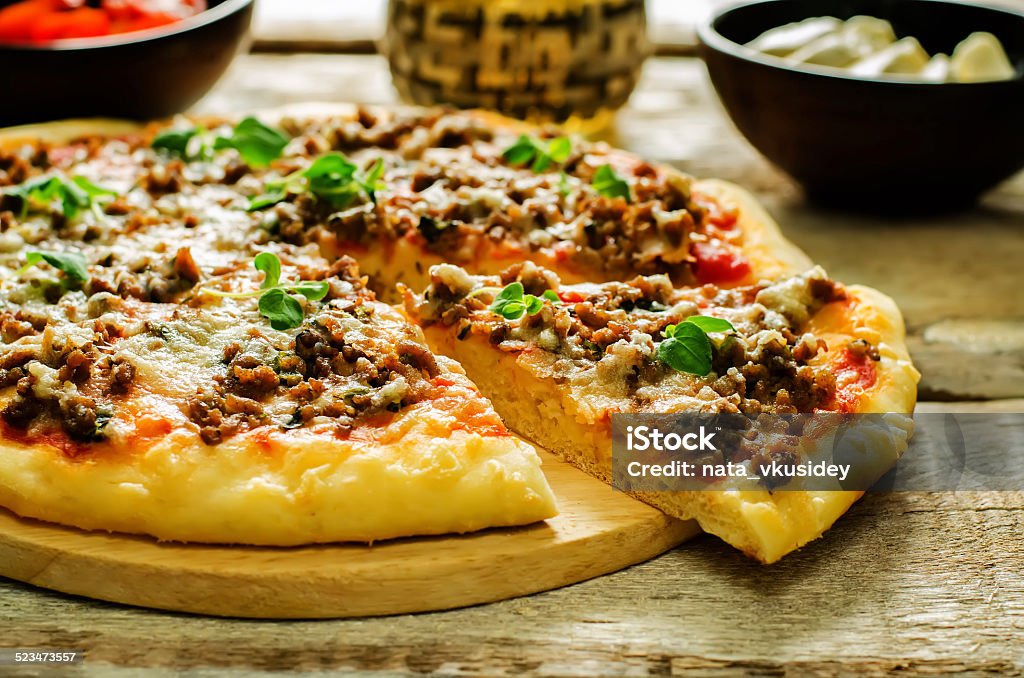 pizza with meat, mozzarella and oregano pizza with meat, mozzarella and oregano on a light woody background. tinting. selective focus Appetizer Stock Photo