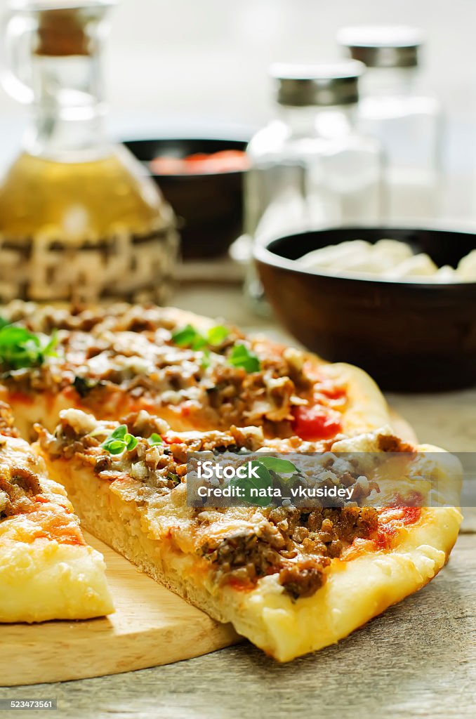 pizza with meat, mozzarella and oregano pizza with meat, mozzarella and oregano on a light woody background. tinting. selective focus Appetizer Stock Photo