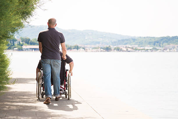 istock senior in wheelchair spending time outdoors with his nurse 523476305