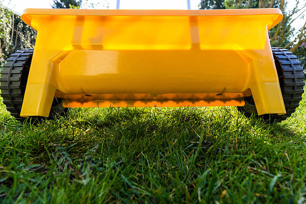 yellow fertilize lawn at garden yellow fertilize lawn at gardenyellow fertilize lawn at garden lawn seeder stock pictures, royalty-free photos & images
