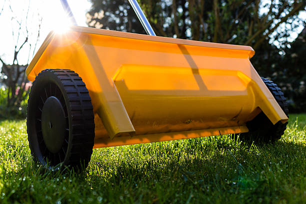 yellow fertilize lawn at garden yellow fertilize lawn at gardenyellow fertilize lawn at garden lawn seeder stock pictures, royalty-free photos & images