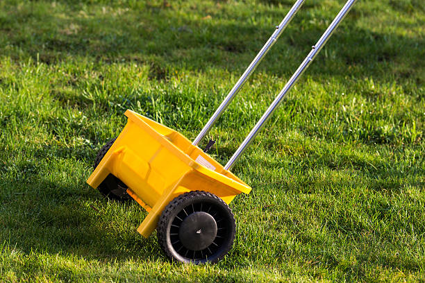 yellow fertilize lawn at garden yellow fertilize lawn at gardenyellow fertilize lawn at garden lawn seeder stock pictures, royalty-free photos & images