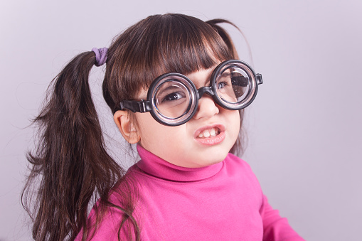 Funny nerdy little girl. Toned image with shallow depth of field