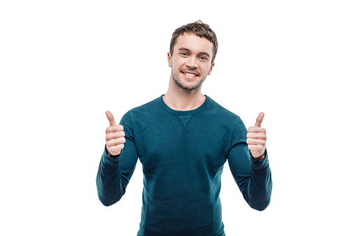 Portrait of stylish handsome young man isolated on white background. Man smiling, showing thumbs up and looking at camera