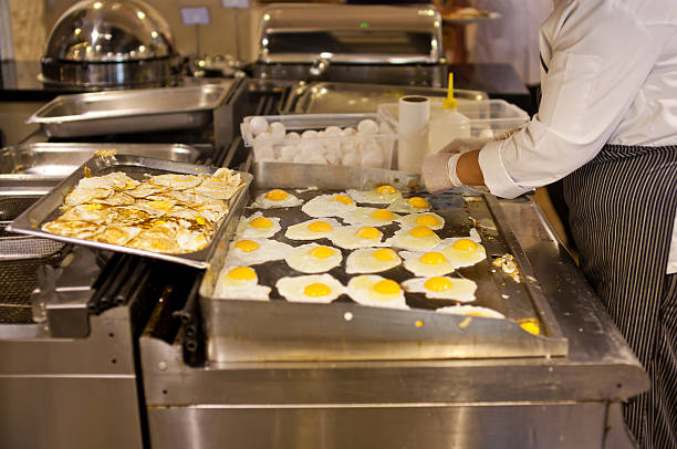 Cozinha um cozinhar é um omelete para o café da manhã - foto de acervo