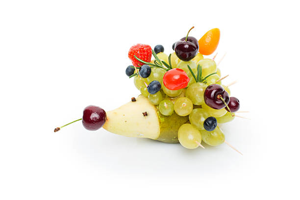 Beautiful fruit snack made in shape of hedgehog. Isolated over white background. Copy space.