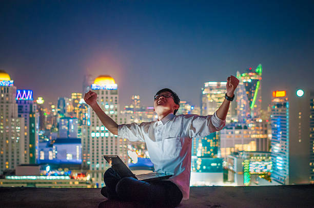istock Businessman using a laptop on the rooftop of a skyscraper 523482080