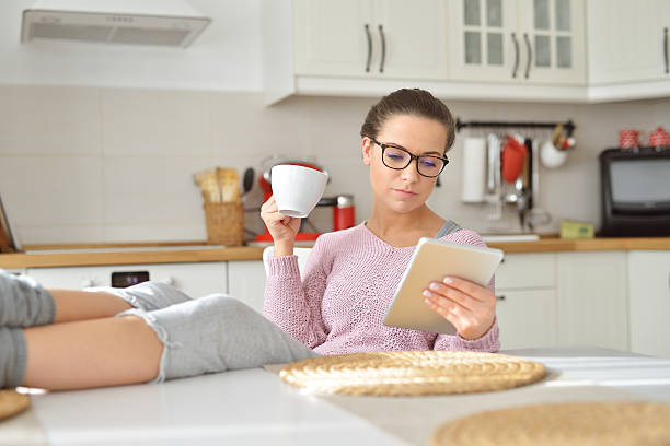 istock She drinks coffee at home and reading on the tablet 523483196