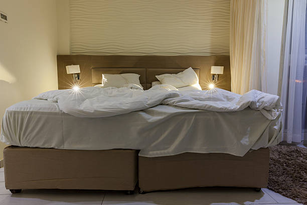 cama de casal do quarto de hotel com cama messed luz de leitura - double bed night table headboard bed - fotografias e filmes do acervo