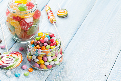 Colorful candies on wooden table background. View with copy space