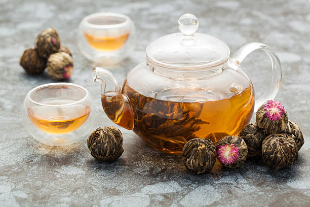 istock exotic green tea glass teapot with floral blooming tea 523490322
