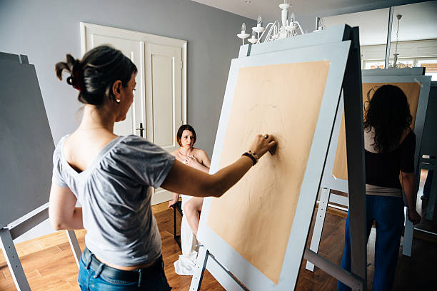 istock Artists in atelier charcoal drawing semi nude model 523494048