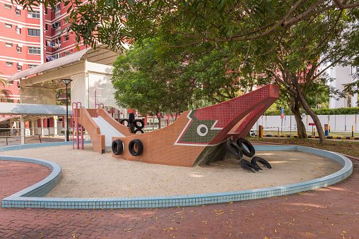 Singapore, Singapore - April 24, 2016: Playground built in the 1980's in the shape of a bumboat at Elias Road in Paris Ris, Singapore. Mosaic tiles were used to decorate the boat and tyres as additional exercise elements. The image was taken mid-afternoon. 
