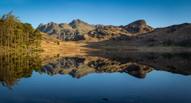 panorama di blea tarn con chiarezza riflessioni. - langdale pikes panoramic english lake district cumbria foto e immagini stock