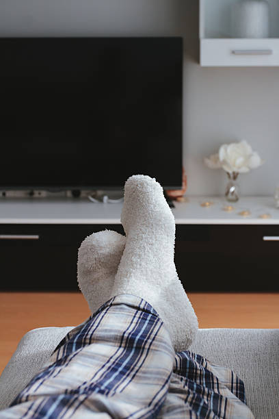 Man feet in front of the tv Man feet in front of the tv at home heat home interior comfortable human foot stock pictures, royalty-free photos & images