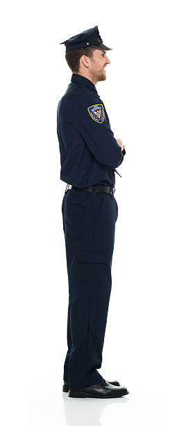 istock Smiling police standing with arms crossed 523498290