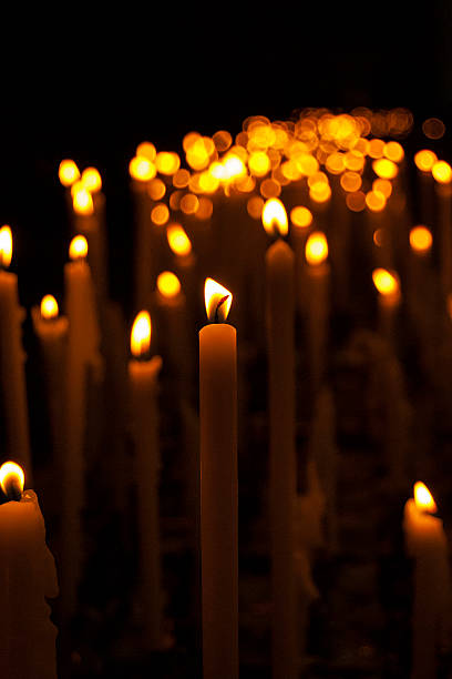 istock lot of thin burning candles, dark background 523500854