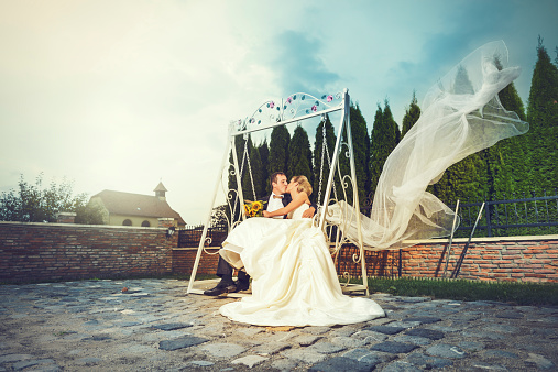 bride and groom on swing kissing.