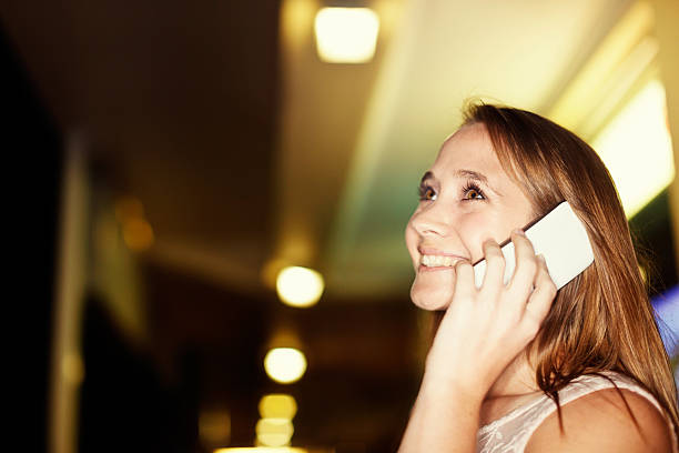 istock Laughing blonde beauty using phone in nighttime shopping district 523513753