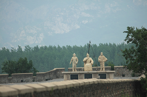 statue of emperor with 2 guards on chinese wall in Shanhaiguan