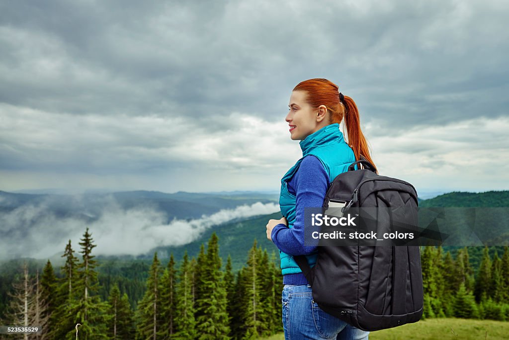 tranquil woman on mountain rear view of red hair woman looking at view. Activity Stock Photo