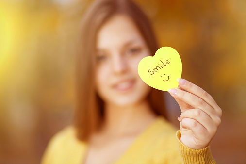 Cheerful beautiful girl holding motivational message