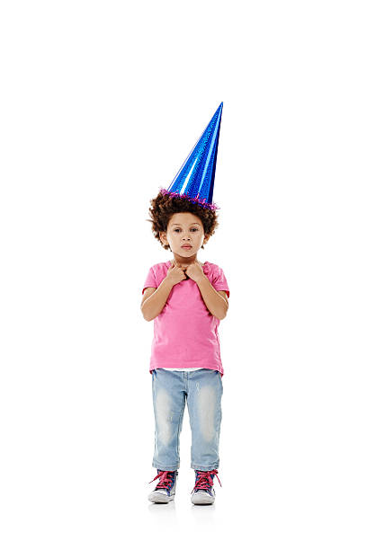 Studio shot of a cute little girl wearing a party hat against a white background