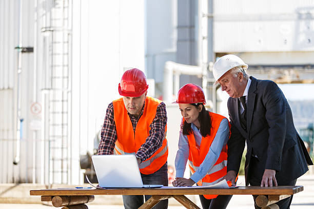 gruppe von industriellen ingenieure, die mit computer im freien - petrochemical plant stock-fotos und bilder