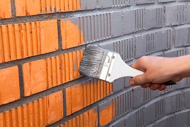istock Human hand painting wall with grey color 523563673