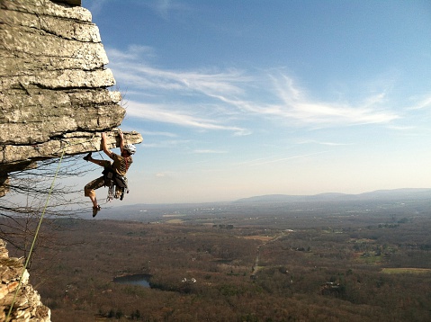 High adventure looms as a rock climber attempts an overhang in the Shawangunk Mountains, NY.