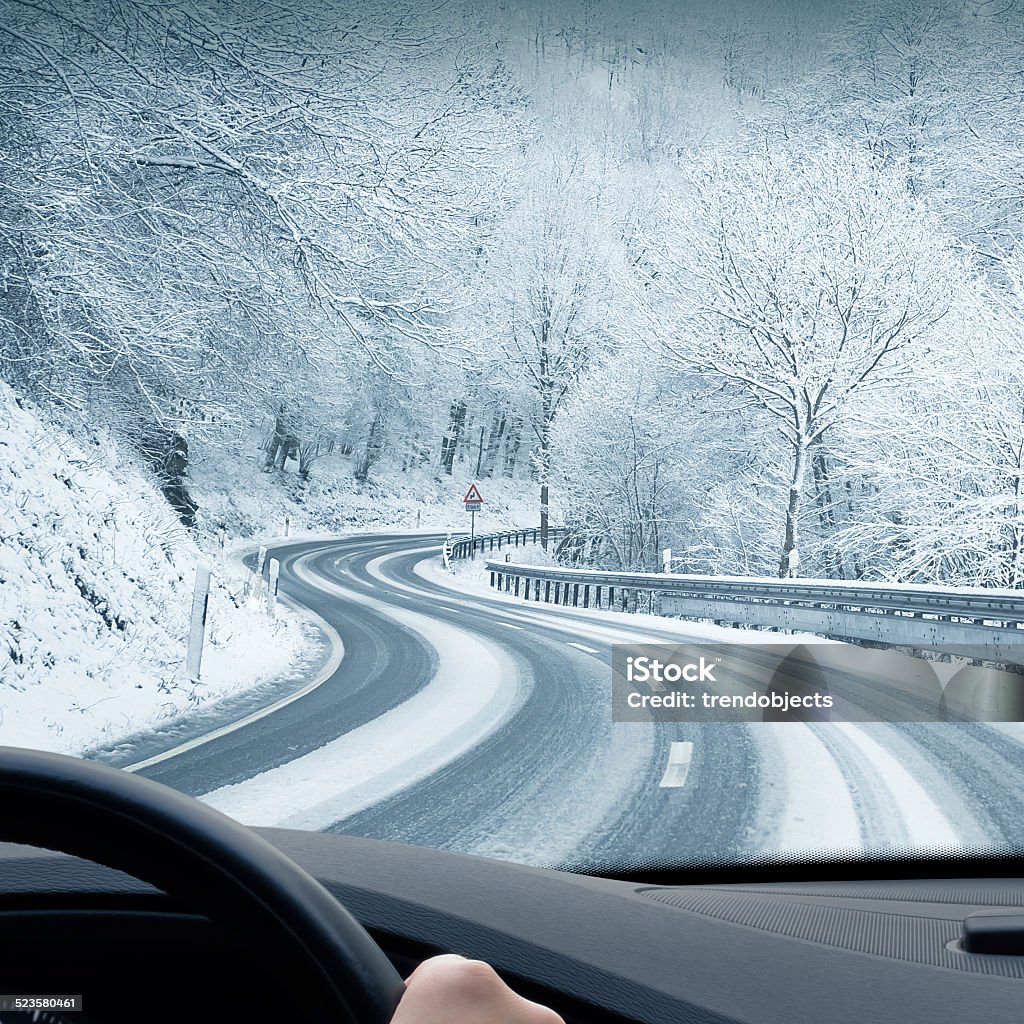 Winter Driving - Curvy Snowy Country Road Curvy winter country road leading through a mountain landscape. Driving Stock Photo