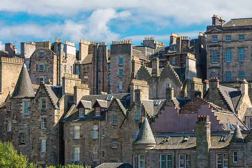 Rocky cliffs in the foreground,dominate the Scotland's capital city,with famous landmarks, Edinburgh Castle set for the Royal MilitaryTattoo,during Fringe Festival,the Hub and St. Mary's Cathedral.