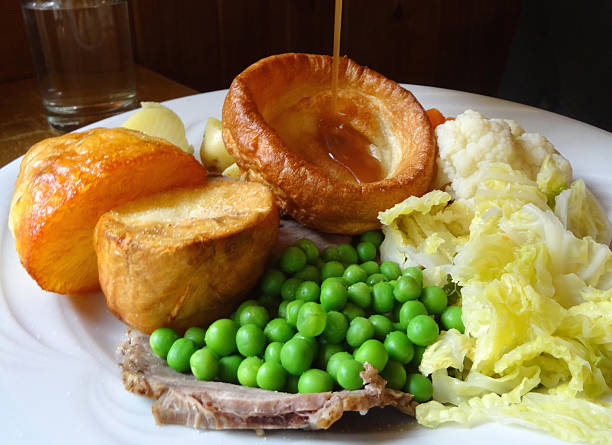 istock Sunday roast dinner, beef, Yorkshire pudding, gravy jug, potatoes, peas 523595091